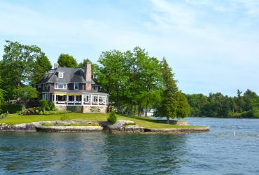 Island with house in Thousand Islands Region in sunny summer day 
