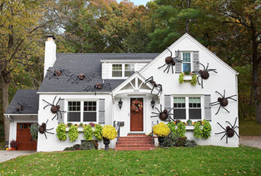 House decorated for Halloween with giant spiders