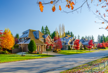 Luxury home with fall leaves and light dusting of snow